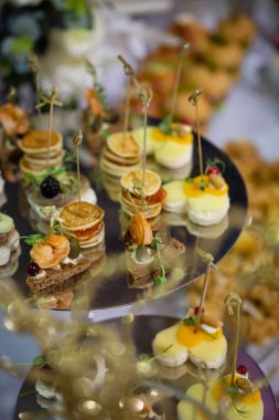 Çeşitli atıştırmalıklar, büfedeki metal tezgahta kanepeler..