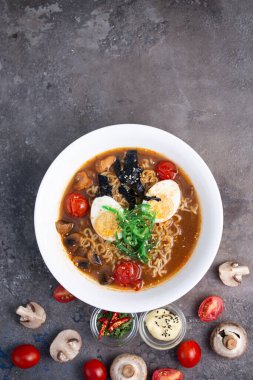 Arka planda sebze manzaralı beyaz tabakta ramen..