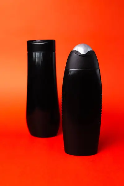 black bottles for household chemicals on a red background.