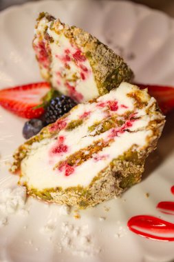 Beyaz plaka üzerindeki bir bölümde bir kremalı pasta rulosunun üst görünümü.