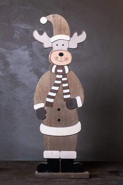 wooden deer figurine made of plywood. decor for the new year on a gray background.