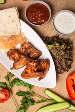 Tavuk kanadı kebabının üst görüntüsü. Bir kafede masada barbekü..