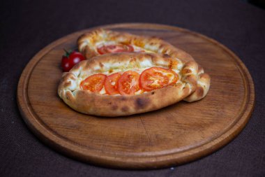 Domatesli khachapuri tarifi. Tahta bir tabakta khachapuri.