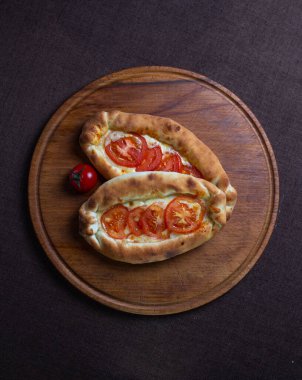 Domatesli Khachapuri tarifi. Tahta bir tabakta khachapuri.