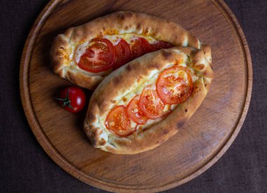 Ahşap tezgahta domatesli Adjarian Khachapuri manzarası..