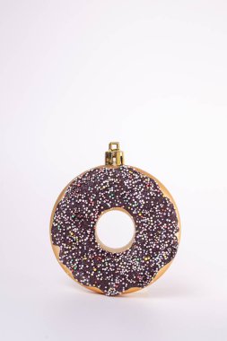 Beyaz arka planda donut şeklinde bir Noel oyuncağı..