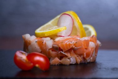 Limon, turp ve kiraz domatesli lezzetli bir somon balığının tadını çıkarın. Lezzetli bir tat ve doku patlaması için..