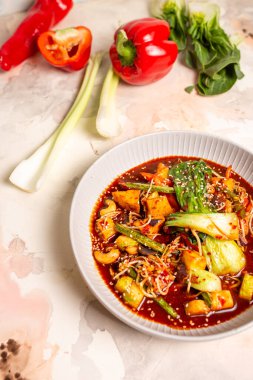 Sebzeli kırmızı köri, beyaz arkaplanda tofu. Hindistan cevizi sütü, kırmızı köri ezmesi, susam tohumuyla süslenmiş..