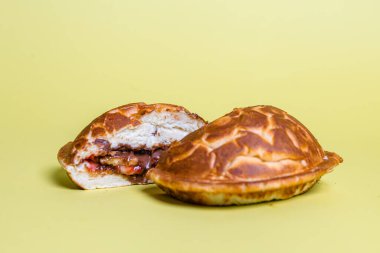 Hamburgerin yarısı ekmeksiz ve köftenin üstünde kızarmış yumurta, pastel sarısı arka planda izole edilmiş..