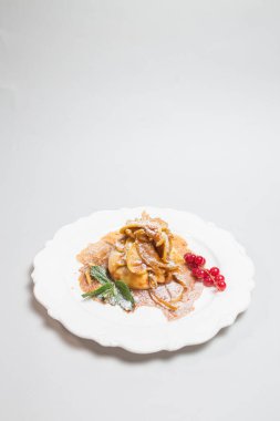 Beyaz bir tabakta servis edilen taze böğürtlen ve nane şekerli leziz krep. Nefis bir kahvaltı ya da kahvaltı için mükemmel bir seçim..