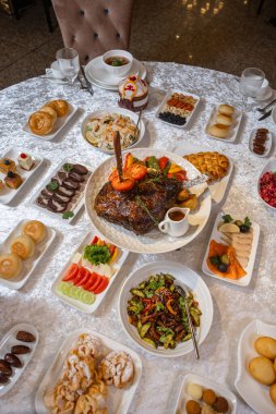 Top view of a lavish banquet table with roasted meat, salads, desserts, and drinks. Perfect for weddings, corporate events, or food photography.