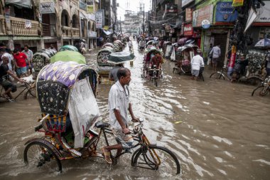 05 Ağustos 2023, Chittagong, Bangladeş: Rickshaws, minibüs, araba ve bisiklet, Chittagong 05 Ağustos 2023 sabahı, Bordharhat bölgesindeki belden aşağı doğru ilerliyorlar. Saatlerce süren aralıksız yağmur, şehrin pek çok bölgesinde su birikintisine yol açarak tarifsiz sulara yol açtı.