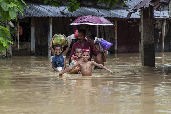 stock image On August 9, 2023 Pedestrians, vans and bicycles are walking along the road flooded with chest and waist level water in Satkania Upazila of South Chittagong, Bangladesh.