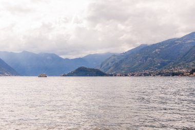 Bellagio, Italy- Eylül 2024 Como Gölü 'nün suyundan rıhtımdaki binalara ve teknelere bakın.