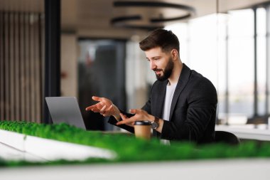 Bilgisayarda video görüşmesi yapan neşeli bir adamın portresi..