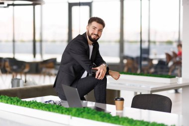 Ofisteki masasında oturan genç adamın portresi.