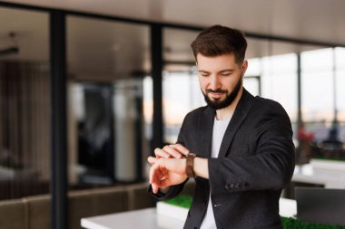 İş adamı ofisteki zamanı kontrol ediyor