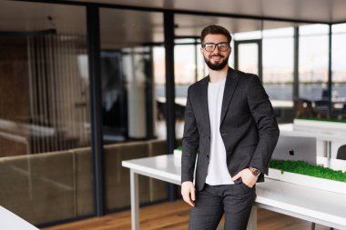 Kendinden emin ve pozitif profesyonel işyeri ofis alanı ile poz işadamı