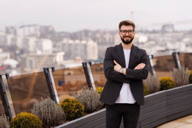 Başarılı bir iş adamı ofis binasında dikilip pencereden dışarı bakıyor ve hayal kuruyor.