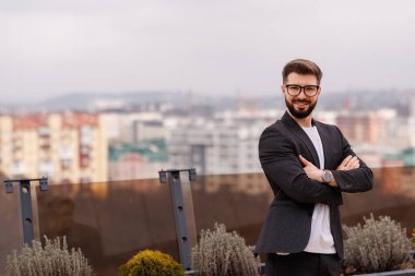 Başarılı bir iş adamı ofis binasında dikilip pencereden dışarı bakıyor ve hayal kuruyor.