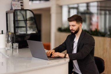 Ofiste arka planda meslektaşlarıyla oturan bir iş adamının portresi. İş yerinde çalışan mutlu bir iş adamı..