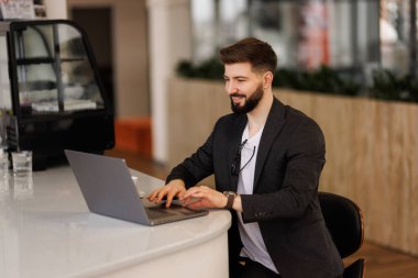 PC klavyesinde yazan, e- postaları kontrol eden, iş yerinde online toplantıya katılan mutlu erkek girişimci