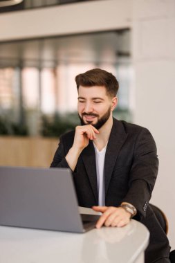 PC klavyesinde yazan, e- postaları kontrol eden, iş yerinde online toplantıya katılan mutlu erkek girişimci