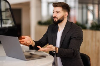 Gözlüklü mutsuz genç beyaz erkek bilgisayar ekranına bakıyor. Cihaz arızası ya da operasyon sorunları yüzünden şokta. Hayal kırıklığına uğramış adam bilgisayar aygıtında beklenmedik bir hata görünce şaşırdı..