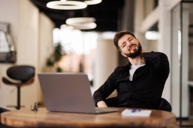 Hasta ve yorgun hissediyorum. Hüsrana uğramış genç bir adam ofisteki iş yerinde otururken burnuna masaj yapıyor ve gözlerini kapalı tutuyor.