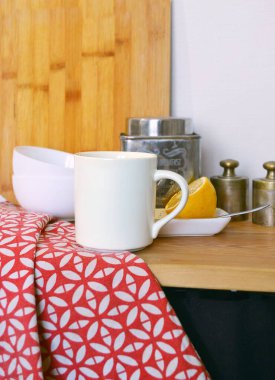 Mutfak tezgahında limonlu ve ağırlıklı beyaz bir kupanın yakın çekimi.