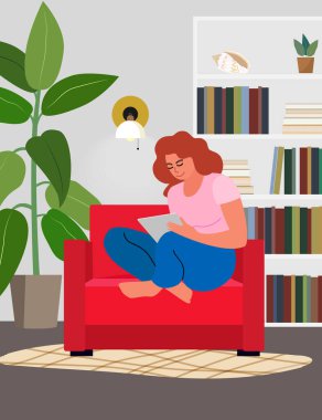 Kitaplık ve bitkilerle kırmızı sandalyede oturan tabletli kadın.