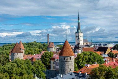 Patkuli izleme platformundan Tallinn 'in manzaralı panoramik manzarası, ortaçağ taş kuleleri, St. Olafs Kilisesi, canlı çatılar ve kısmen güneşli bir günde Baltık Denizi.