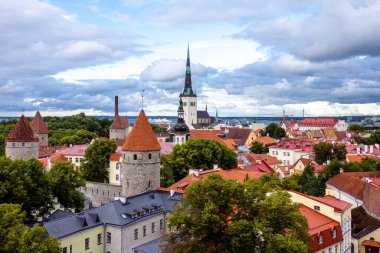 Patkuli platformundan Tallinn Eski Kasabası 'nın panoramik manzarasında ortaçağ kuleleri, kırmızı çatılar ve Estonya' da bulutlu bir yaz gökyüzü altında St. Olafs Kilisesi 'nin yüksek kulesi yer alıyor..