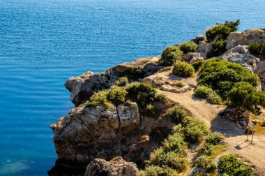 Açık bir yaz gününde deniz manzaralı ve parlak Akdeniz manzaralı Heraion, Perachora, Corinth, Yunanistan arkeolojik sahasında kayalık yol.