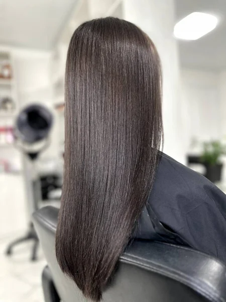 woman with long dark hair, beautiful hair, dyed hair in a beauty salon, hair coloring