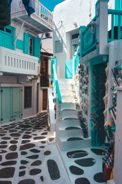 Kiklad Yunan adası Mykonos 'un eşsiz mimarisi, mavi pencereli klasik beyaz evler tarafından temsil ediliyor. Sokaklar çiçek açan ağaçlarda gömülü. Yunanistan 'ın en lüks tatil köyü. Yunan Adası Mykonos Sokağı