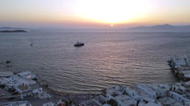 Mykonos Adası 'nın ikonik beyaz evleri ve gün batımında büyüleyici mavi deniz manzarası. Lüks tatil köyü