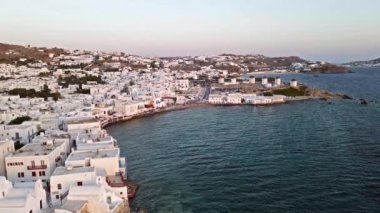 Mykonos Adası 'nın ikonik beyaz evleri ve gün batımında büyüleyici mavi deniz manzarası. Lüks tatil köyü