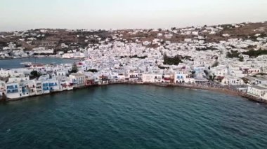 Mykonos Adası 'nın ikonik beyaz evleri ve gün batımında büyüleyici mavi deniz manzarası. Lüks tatil köyü