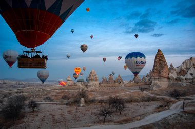 Kapadokya dağlarında renkli sıcak hava balonu, hindi. Kış gündoğumu. Bir balonun kovasından görüntü