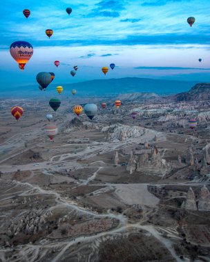 Kapadokya dağlarında renkli sıcak hava balonu, hindi. Kış gündoğumu. Bir balonun kovasından görüntü