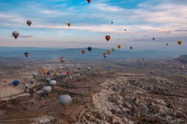 Kapadokya dağlarında renkli sıcak hava balonu, hindi. Kış gündoğumu. Bir balonun kovasından görüntü
