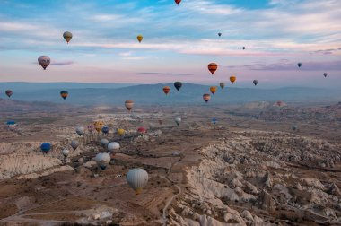 Kapadokya dağlarında renkli sıcak hava balonu, hindi. Kış gündoğumu. Bir balonun kovasından görüntü