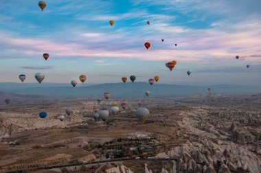 Kapadokya dağlarında renkli sıcak hava balonu, hindi. Kış gündoğumu. Bir balonun kovasından görüntü