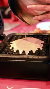 Kadın masanın üzerinde çikolatalı ve kremalı pasta yapıyor..