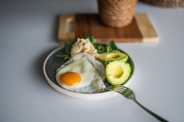 Taze pişmiş sağlıklı organik Ayurvedic kahvaltı çiftçinin sahanda yumurtası, humus ve organik otlar, avokado..
