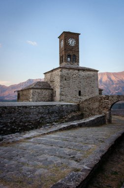 Osmanlı mirasının açıkça görüldüğü Arnavutluk 'un güzel bir kasabası olan Cirokaster' daki saat kulesi ve kalenin üzerinde gün batımı. Şehrin yukarısında büyük şato panoramik manzaralar sunar..