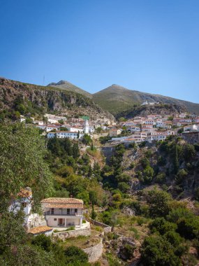 Coastal village of Dhermi with white houses on the slope of mountains. Albania. High quality photo clipart