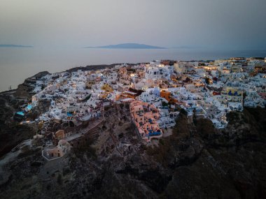 Oia, Santorini 'nin beyazlatılmış köyünün nefes kesici hava manzarası, Ege Denizi' ne bakan sonsuz havuzlu lüks tatil beldelerini gösteriyor. Kiklad mimarisinin çarpıcı bir karışımı.