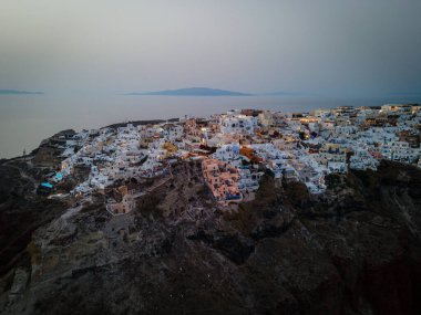 Oia, Santorini 'nin beyazlatılmış köyünün nefes kesici hava manzarası, Ege Denizi' ne bakan sonsuz havuzlu lüks tatil beldelerini gösteriyor. Kiklad mimarisinin çarpıcı bir karışımı.